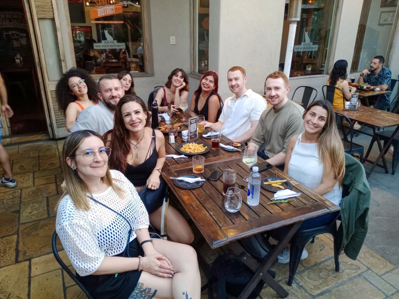 Personas disfrutando del verano en una mesa al aire libre en un espacio de coworking