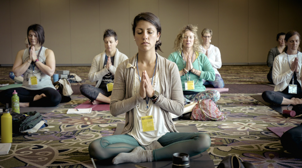 mujeres meditando sobre alfombras en la sala de cowork de la maquinita