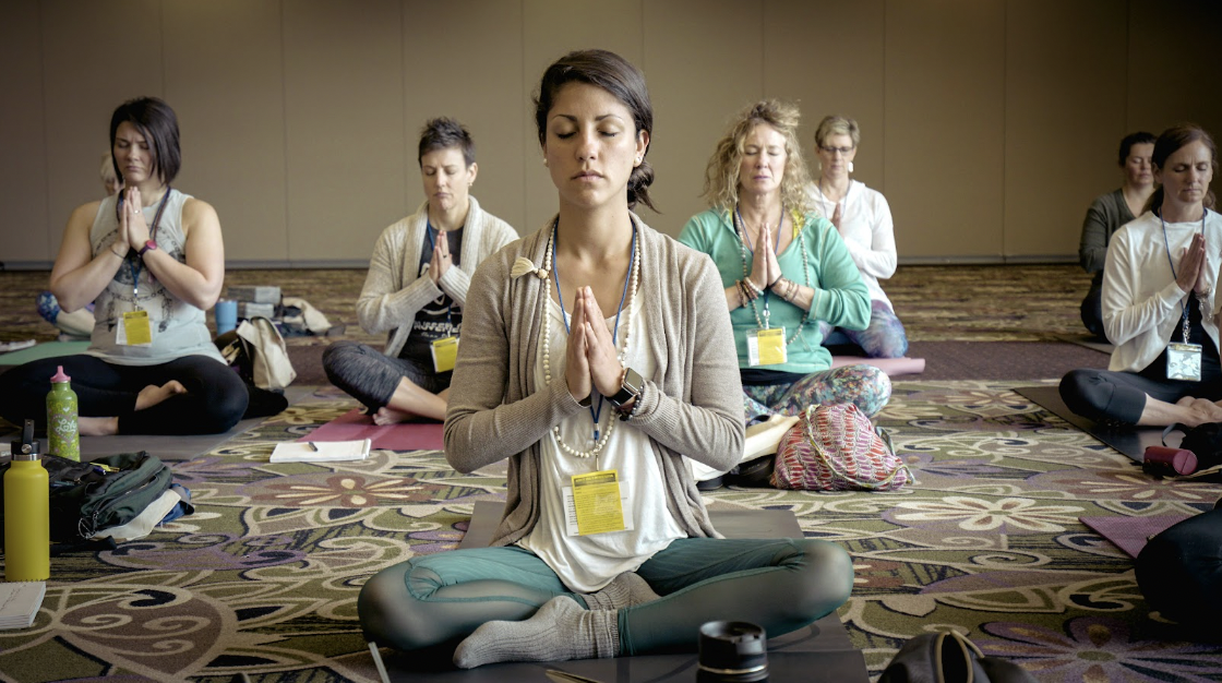mujeres meditando sobre alfombras en la sala de cowork de la maquinita